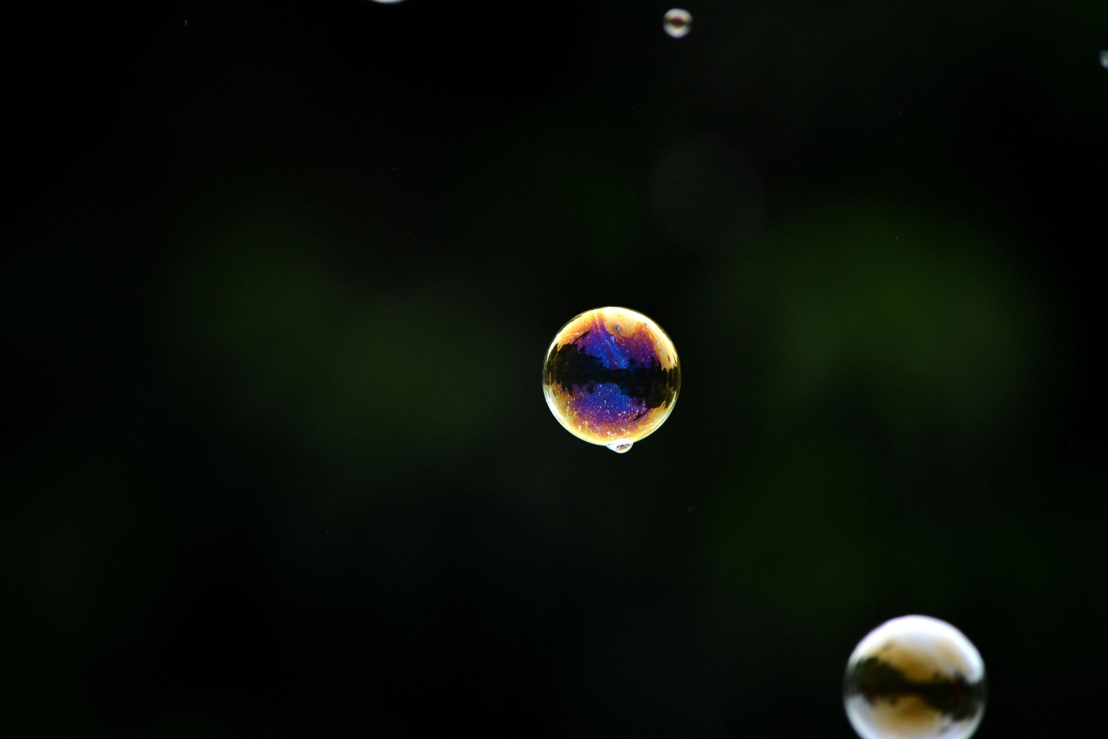 A single translucent bubble floating against a dark background.
