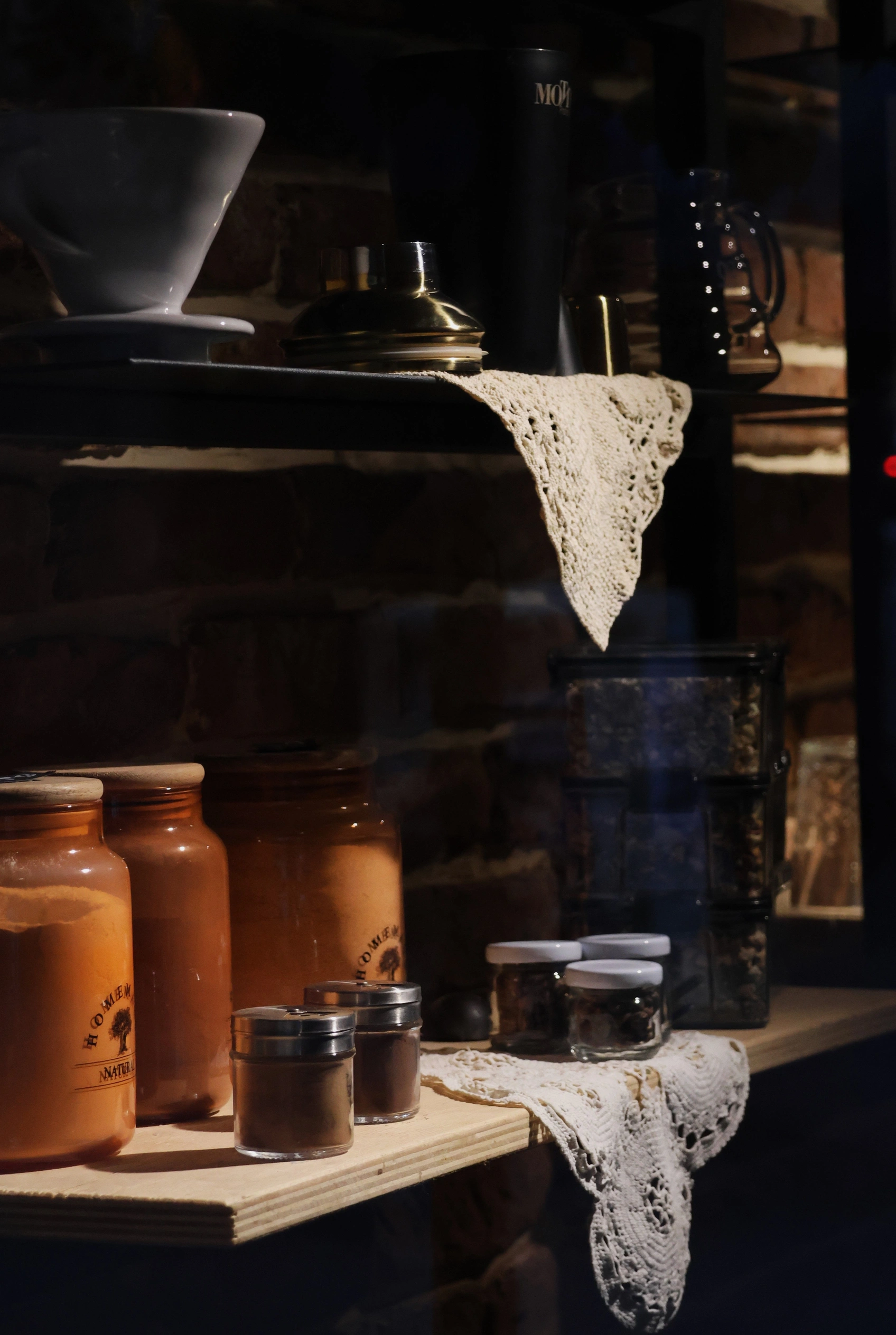 Dark apothecary shelves lined with jars and bottles, lit low.