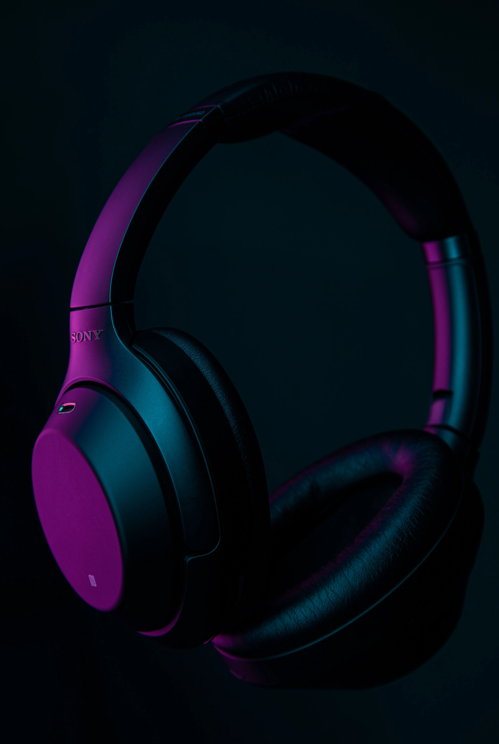 Over-ear headphones resting on a dark surface.