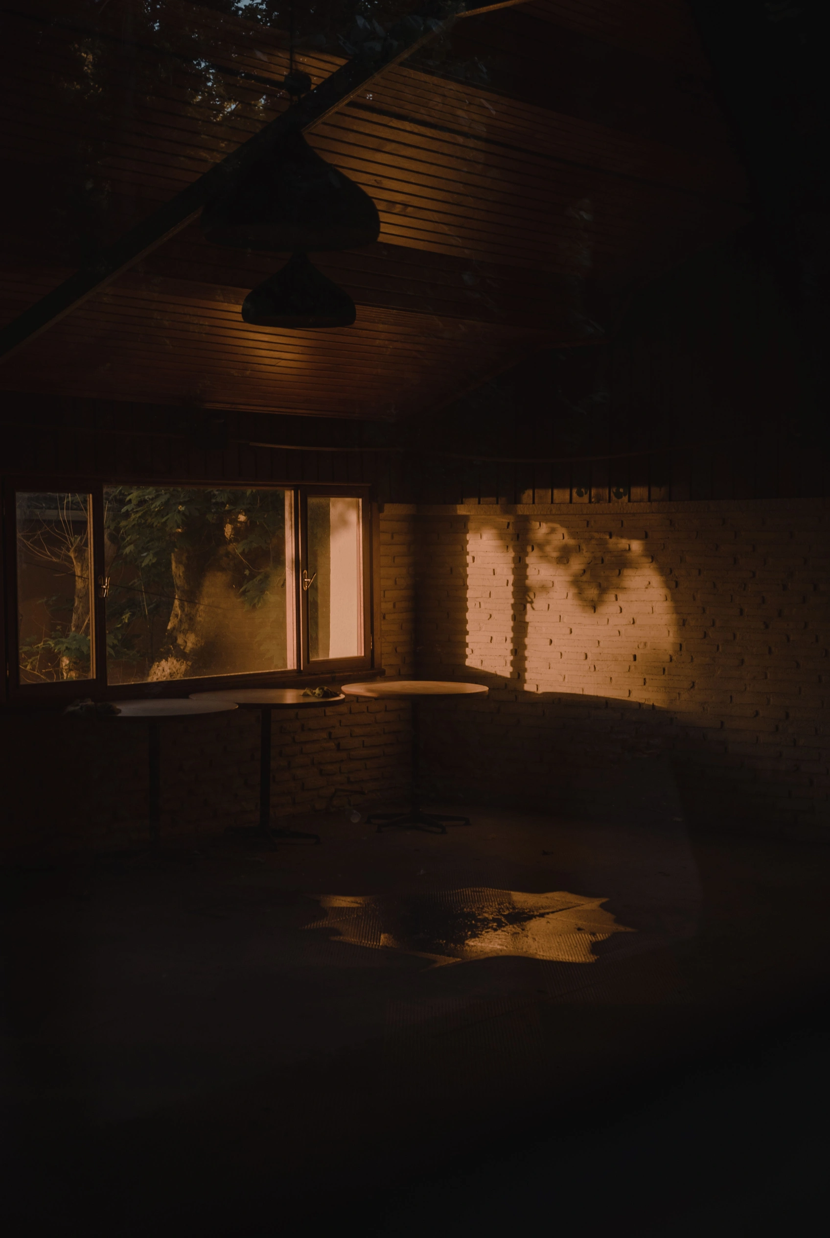 Dim light falling through a window into a dark stone room.