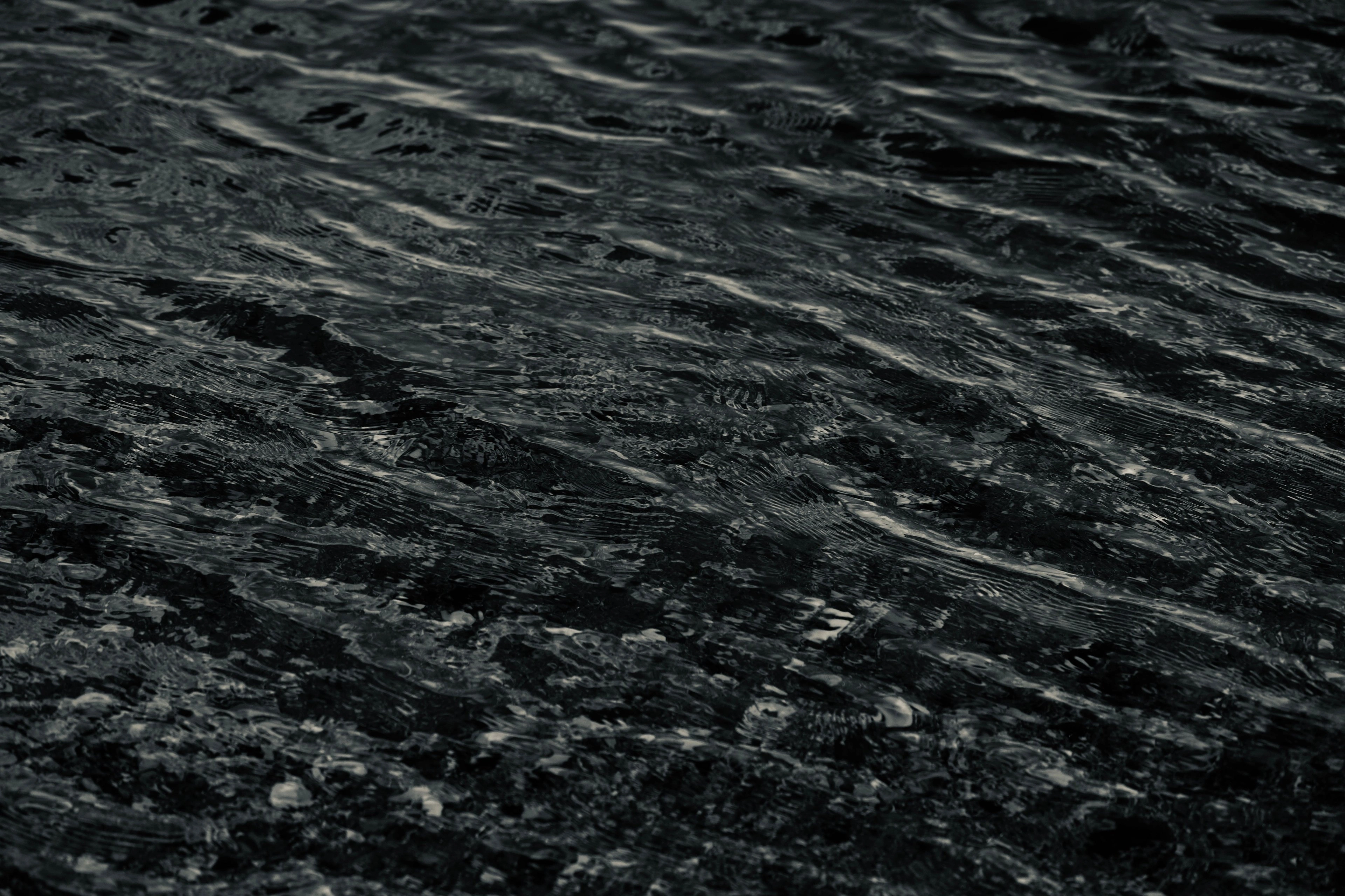 Fine ripples moving across dark, textured water.