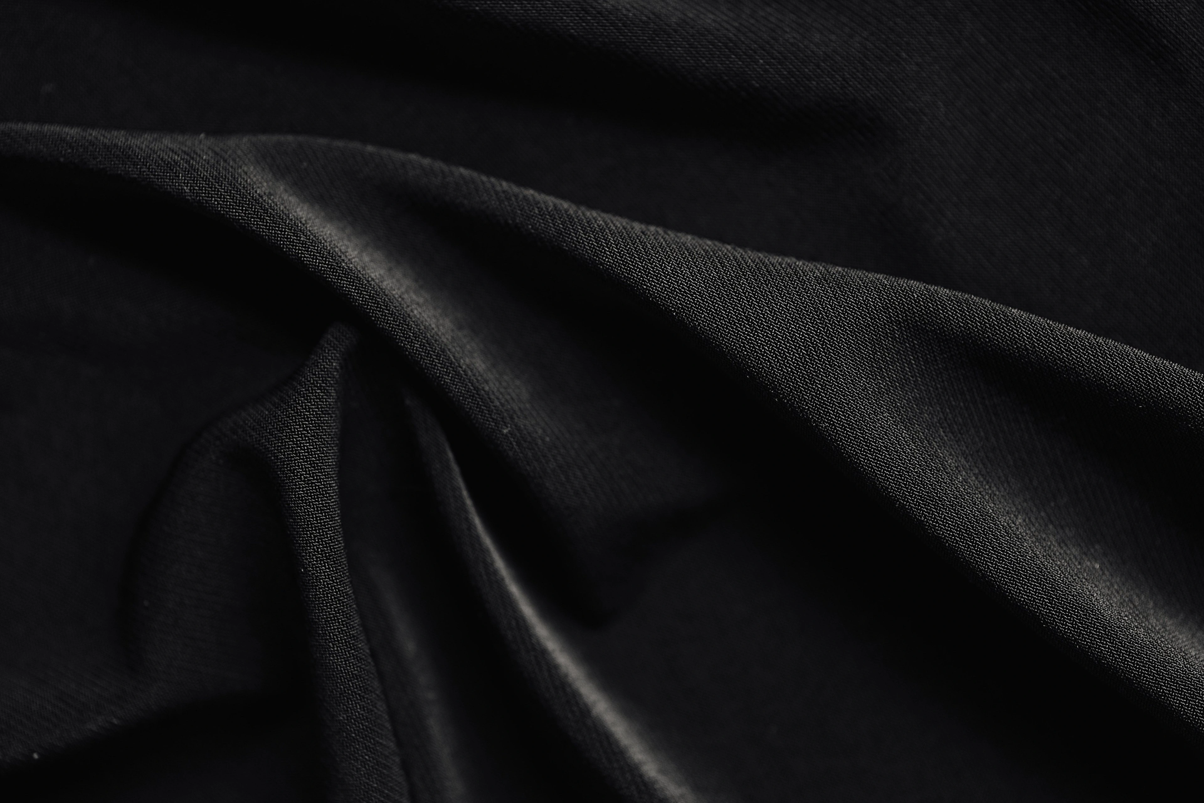 Dark draped linen catching a soft sheen of light.