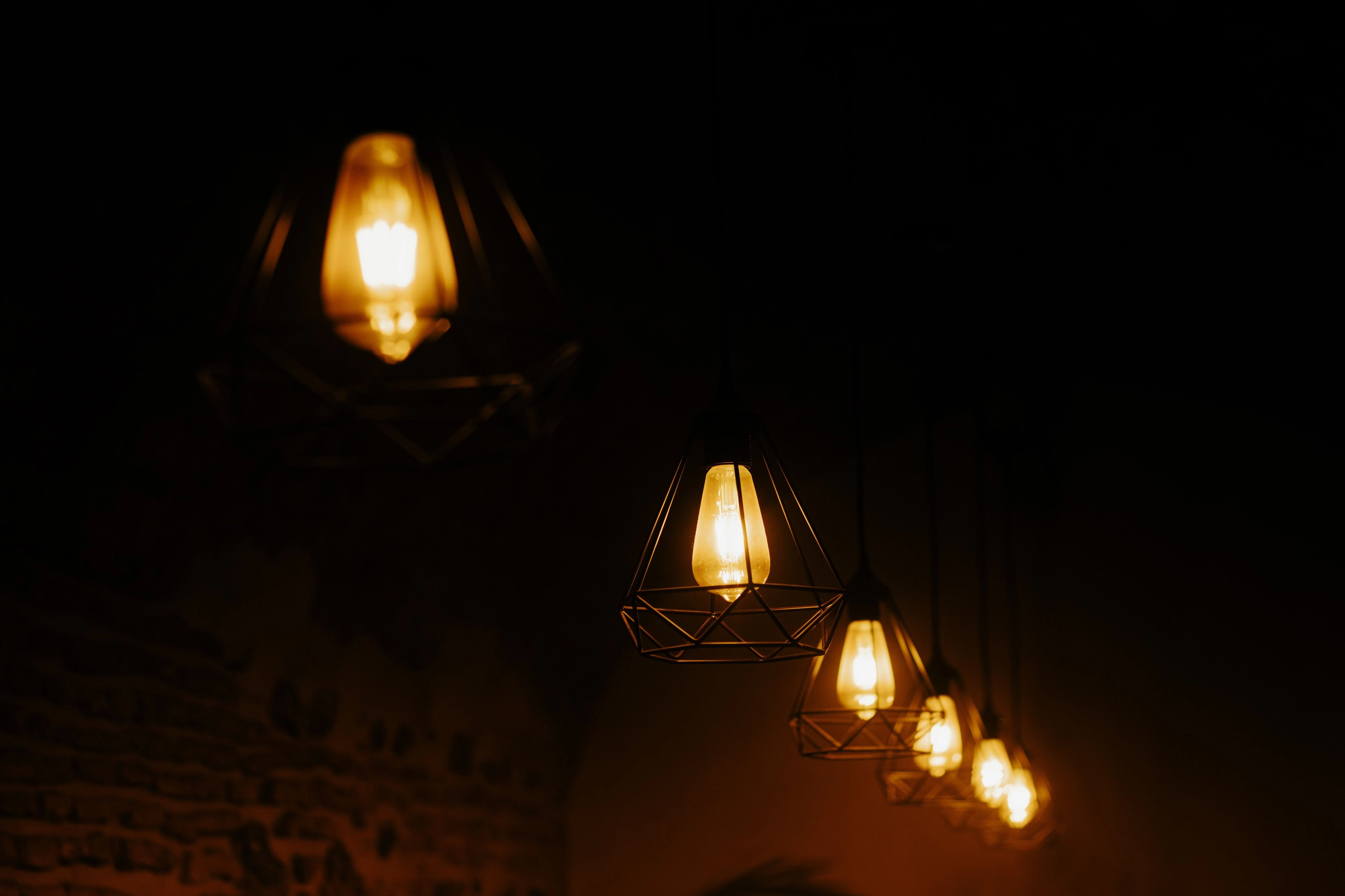 A cluster of warm filament bulbs hanging in a dark space.