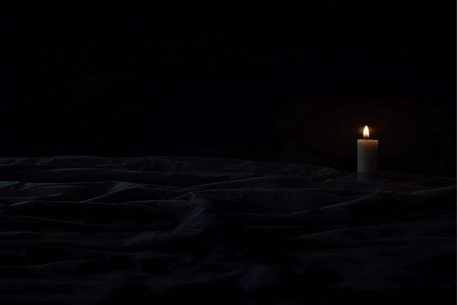 A tightly tucked linen bedsheet on a dark wooden floor with a single gold candle flickering in the distance.